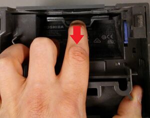 Flip the unit over again and pull the tab back as indicated. This will allow the outer cover to slide up and off.