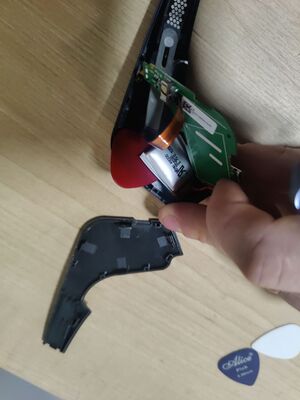 Using a guitar pick to pry the battery in the Muse (2016) loose