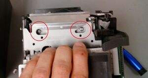 Position the unit on its back then remove the two indicated screws (A magnetic tipped screwdriver is highly recommended)